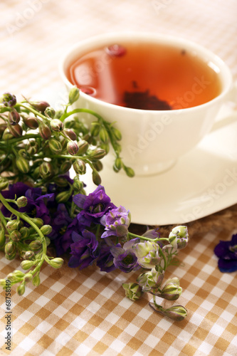 Cup of fresh herbal tea on table