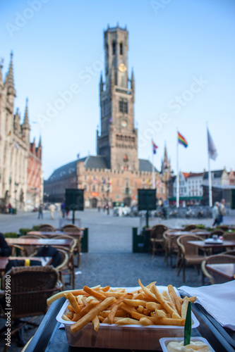 Typical belgian meal - frie; Bell Tower in Bruges. Shallow DOF. photo