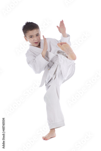 Young boy training kick isolated on white background