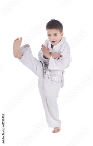 Young boy training kick isolated on white background