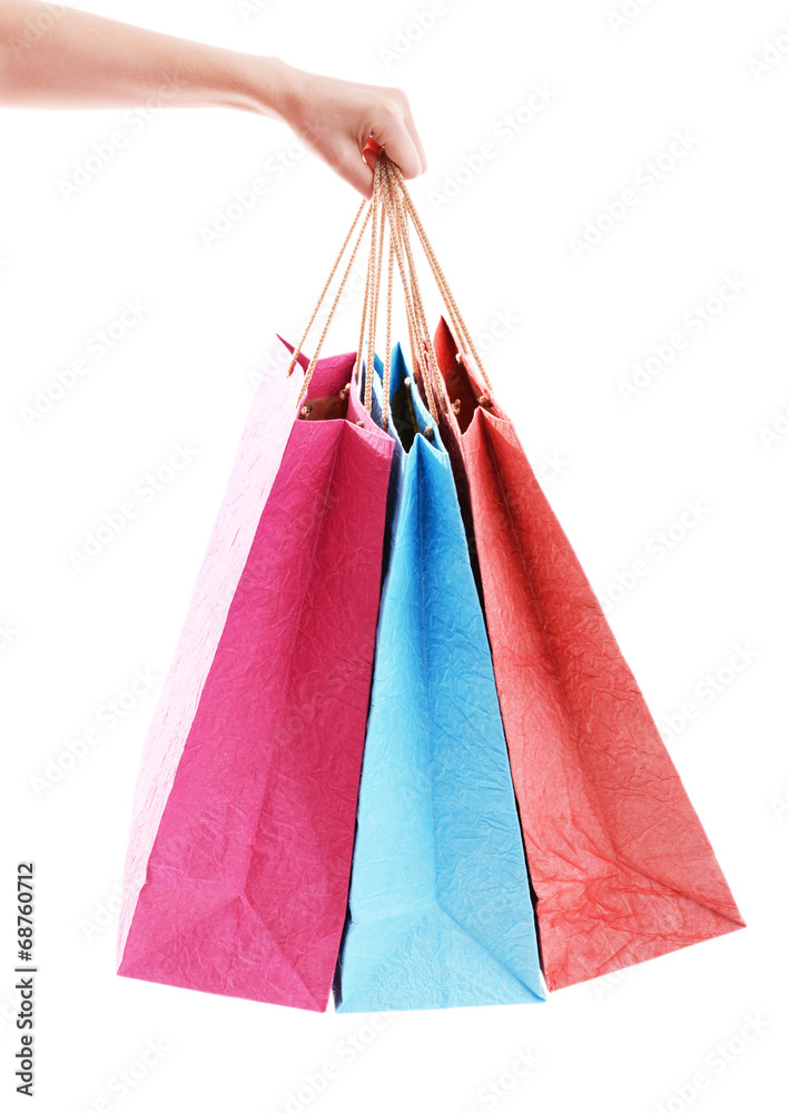 Female hand holding paper shopping bags isolated on white