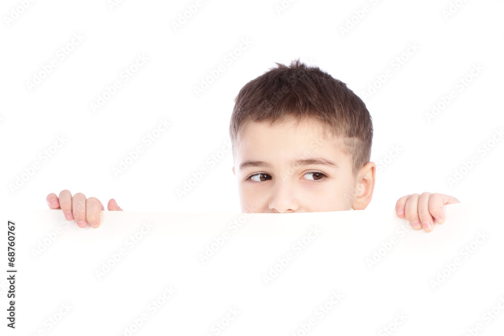 Young boy hiding behind a billboard and making a face on camera Young boy hiding behind a billboard and making a face on camera