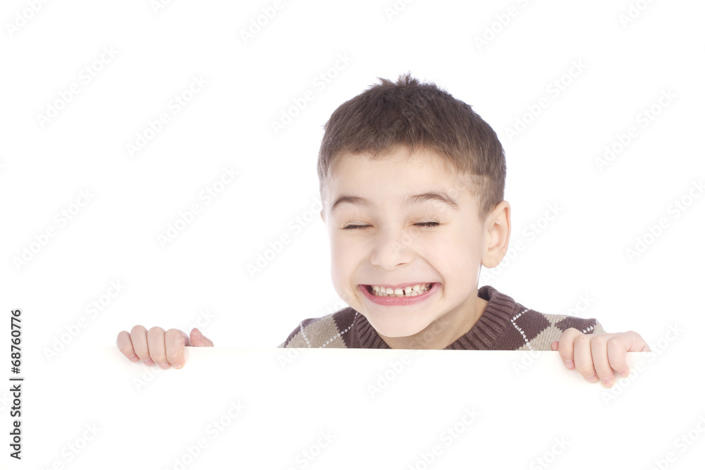 Young boy hiding behind a billboard and making a face on camera Young boy hiding behind a billboard and making a face on camera