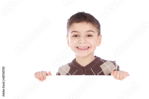 Young boy hiding behind a billboard and making a face on camera