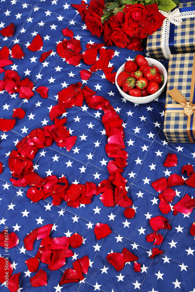 Fototapeta premium Romantic still life with strawberry, gift boxes and petals of