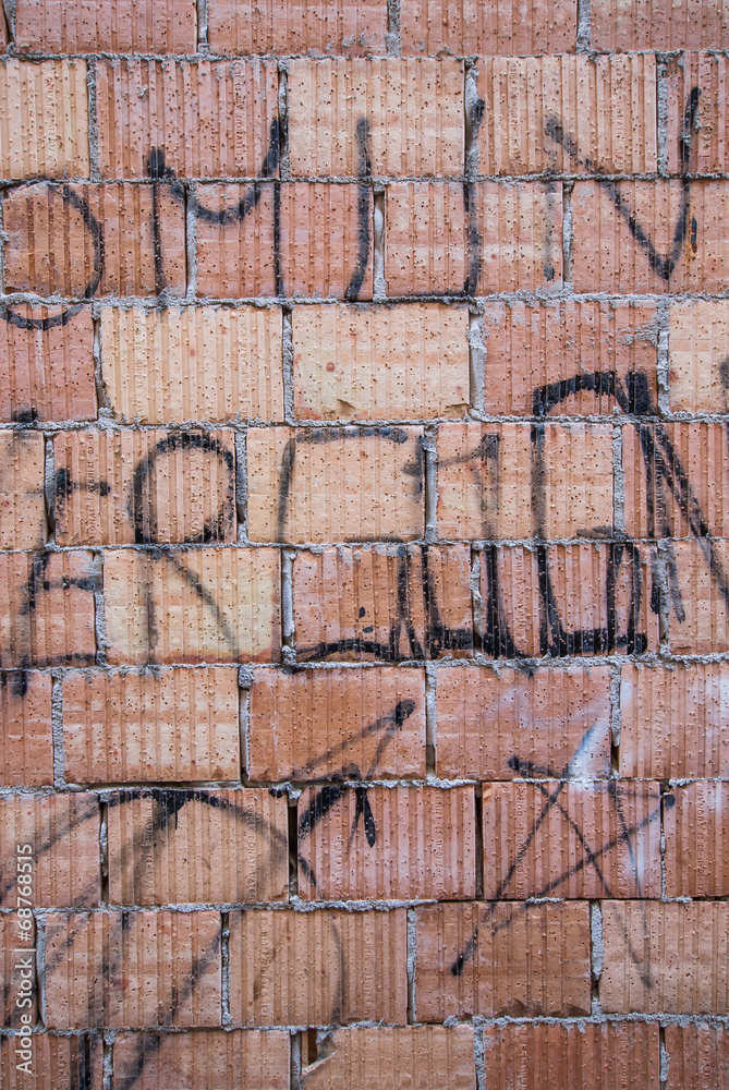 Muro di mattoni con scritte e graffiti Muro di mattoni con scritte e graffiti