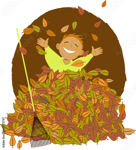 Little boy playing in a pile of fallen leaves