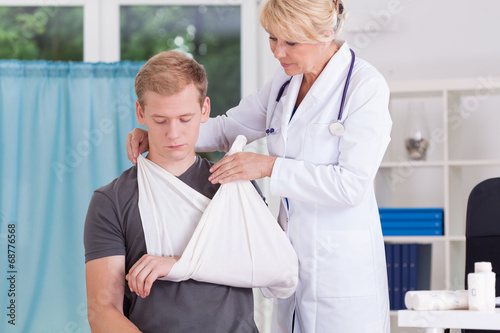 Doctor putting on sling photo