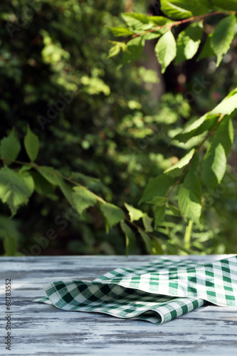 Wooden table with tablecloth, outdoors photo