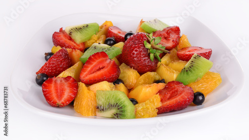 Fresh fruits salad on plate isolated on white