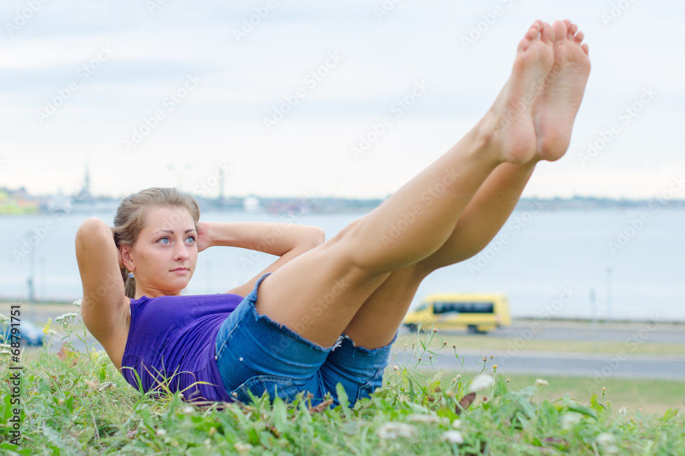 Pretty woman doing exercises for the abs in the park. Pretty woman doing exercises for the abs in the park.