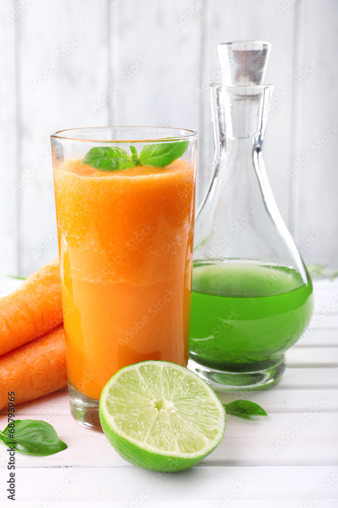 Glass of fresh carrot juice, decanter of lime juice, lime, Glass of fresh carrot juice, decanter of lime juice, lime,