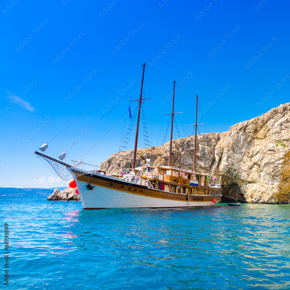 Naklejka premium Vintage sailing boat in bay.