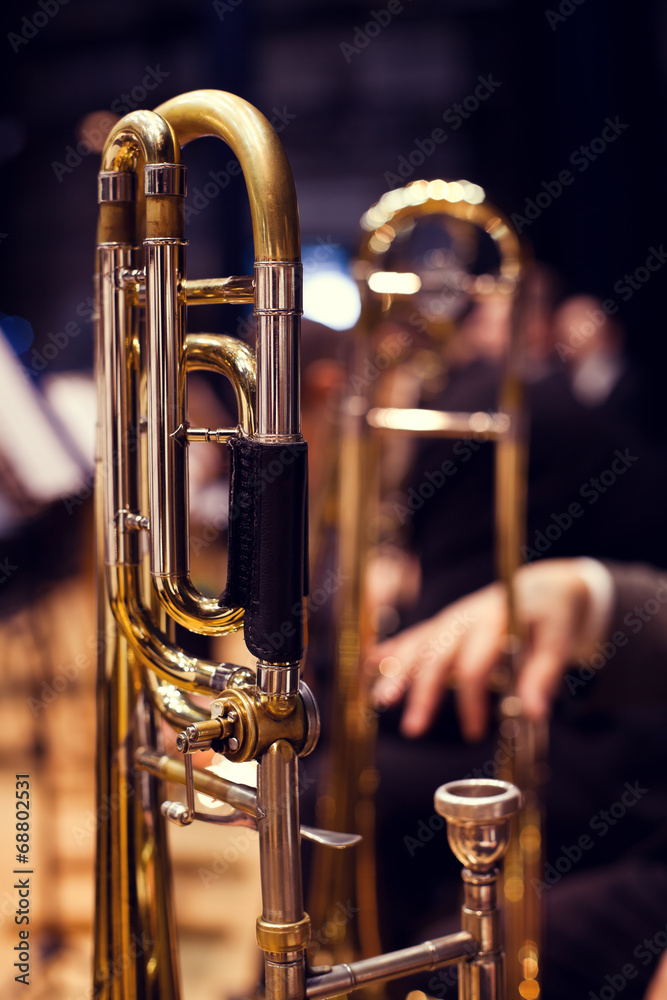 Obraz premium Trombones in the hands of musicians on stage