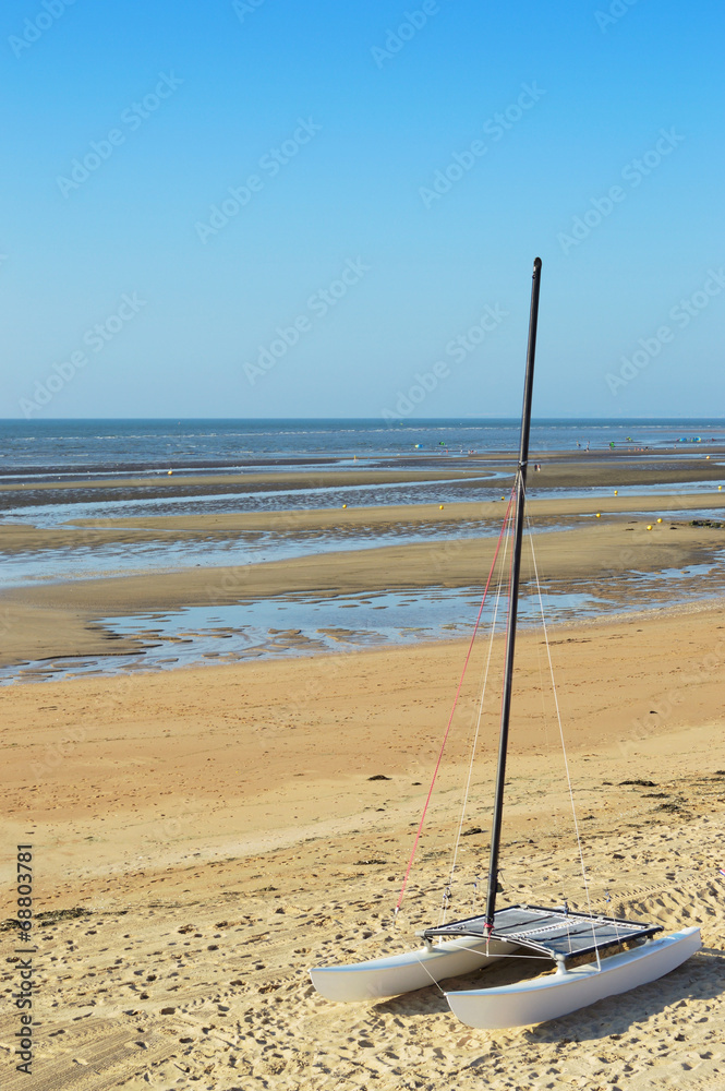 Segelkatamaran auf dem Strand mit Meereshintergrund Segelkatamaran auf dem Strand mit Meereshintergrund