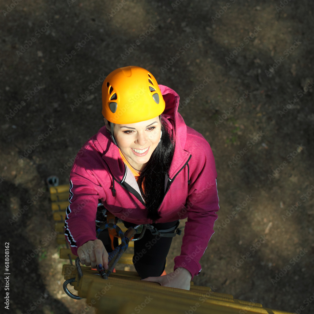 Fototapeta premium Beautiful girl climber climbs up the stairs