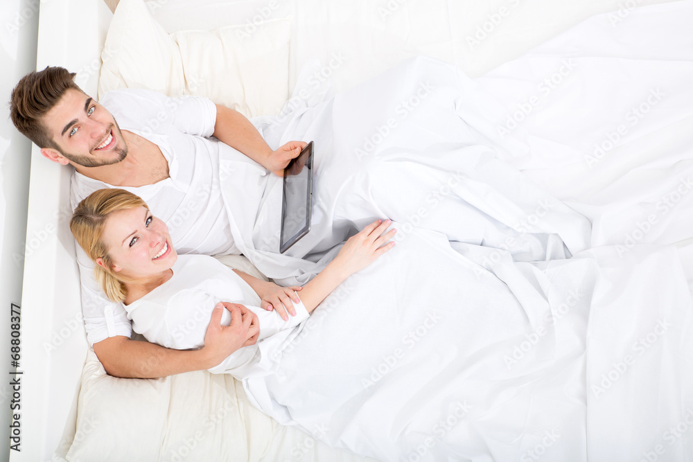 Glückliches Pärchen mit Tablet Pc im Bett Glückliches Pärchen mit Tablet Pc im Bett