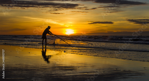 Fishermen fishing in the sea at sunrise