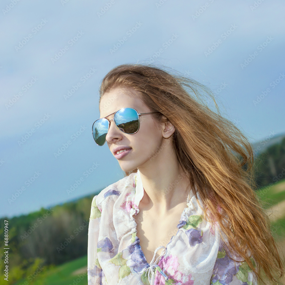 portrait of red long-haired beautiful girl in  sunglasses
