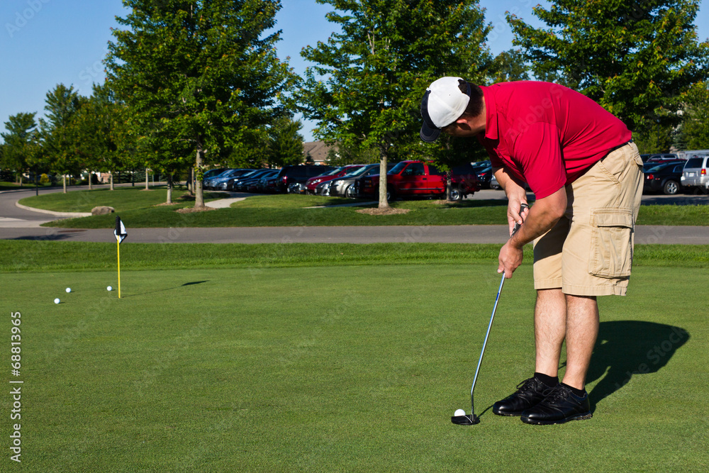 Obraz premium Golfer practicing putting golf balls