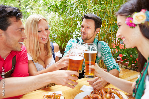 Freunde sto  en mit Bier an im Biergarten