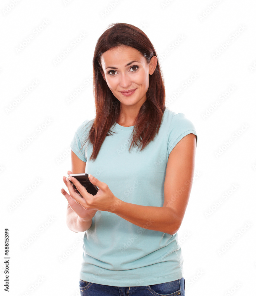 Cheerful brunette texting and smiling at you Cheerful brunette texting and smiling at you