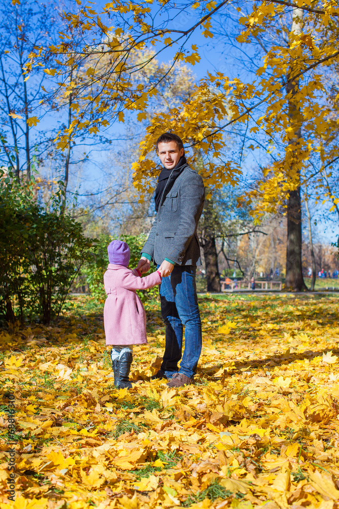 Adorable little girl with happy father outdoor in autumn park