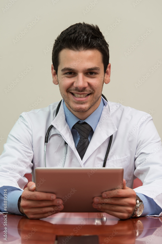 Young Doctor Working On Touchpad In Office Young Doctor Working On Touchpad In Office