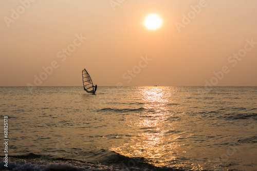 Windsurfer silhouette in front of sunset background
