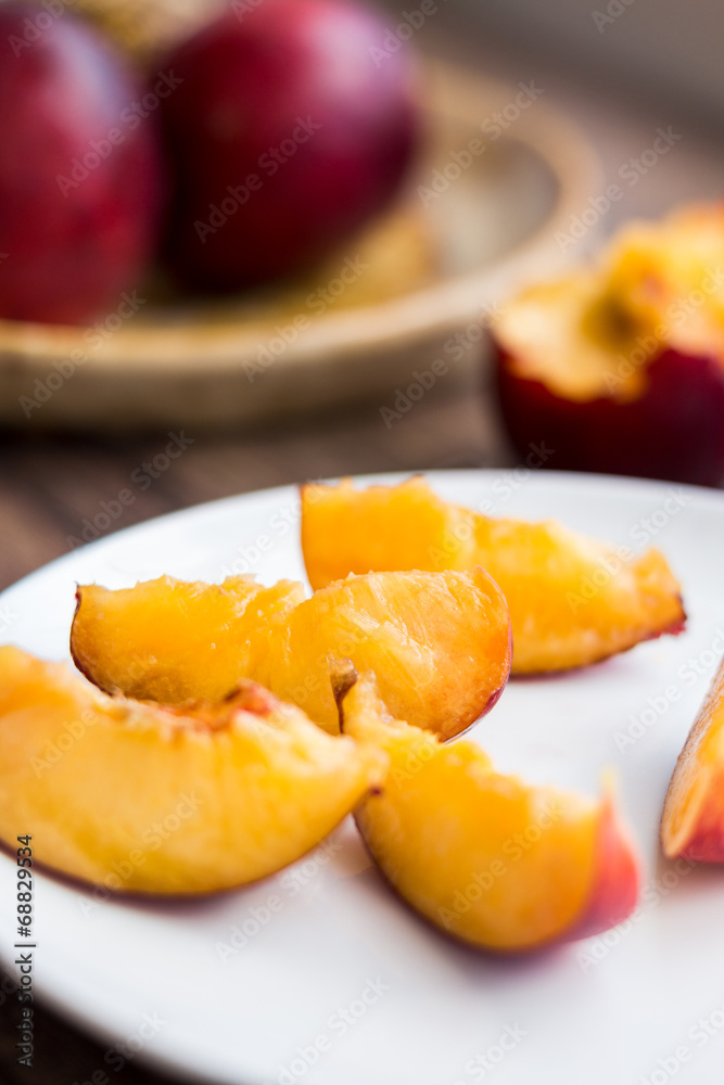 bright peach slices on white round plate, close up