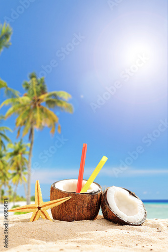 Creative cocktail in coconut cup on a tropical beach