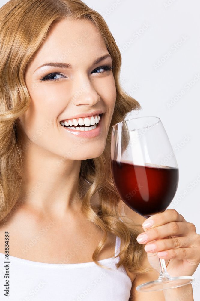 Young happy woman with glass of red wine, on gray Young happy woman with glass of red wine, on gray