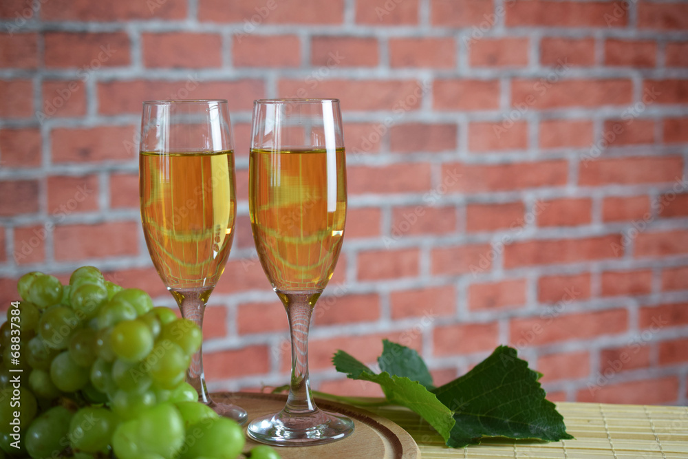 Grapes and two glasses of the white wine. Red brick Grapes and two glasses of the white wine. Red brick