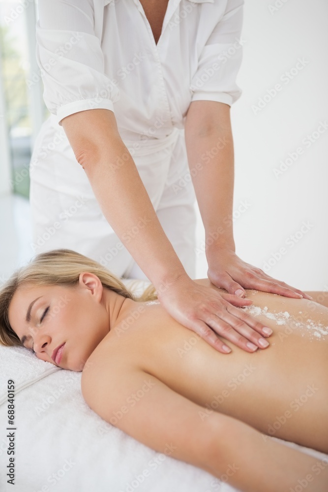 Obraz premium Beautiful blonde enjoying a salt scrub treatment