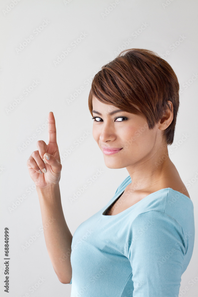 woman raising one finger or pointing her finger upward woman raising one finger or pointing her finger upward