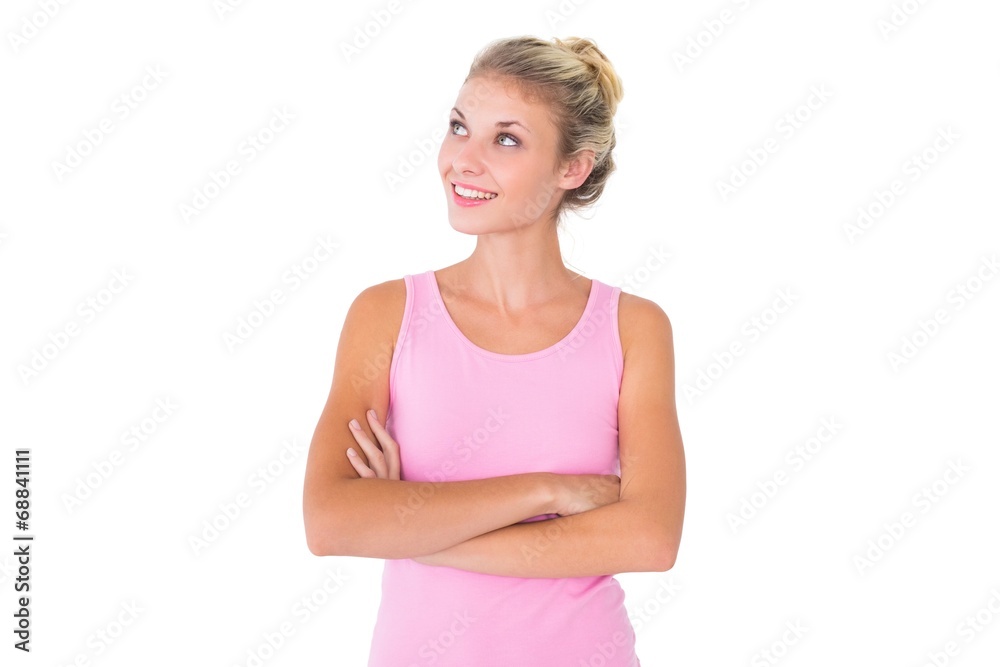 Pretty young blonde in pink looking up with arms crossed Pretty young blonde in pink looking up with arms crossed