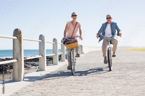 Happy casual couple going for a bike ride on the pier