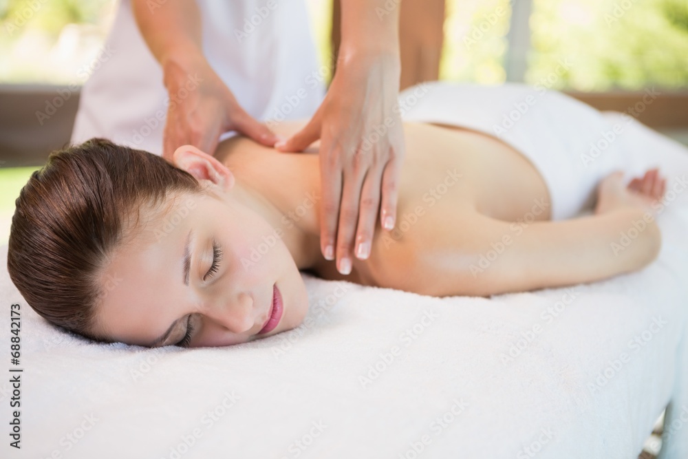 Attractive woman receiving back massage at spa center Attractive woman receiving back massage at spa center