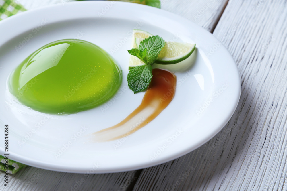 Green jelly with mint leaves on wooden background Green jelly with mint leaves on wooden background