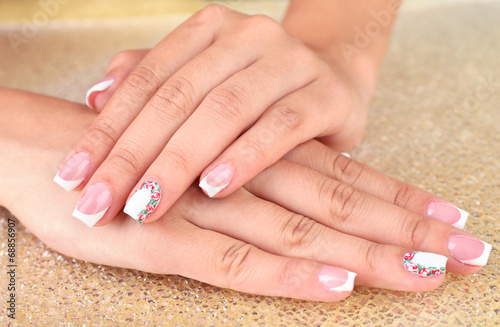 Female hand with stylish colorful nails on bright background