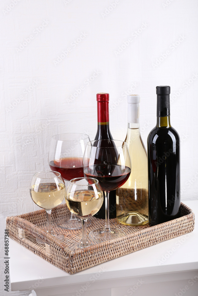 Fototapeta premium Bottles and glasses of wine on table in room