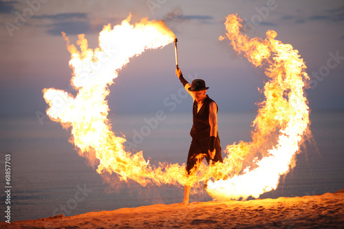 Foto Awesome fire show on the beach; circle of flame
