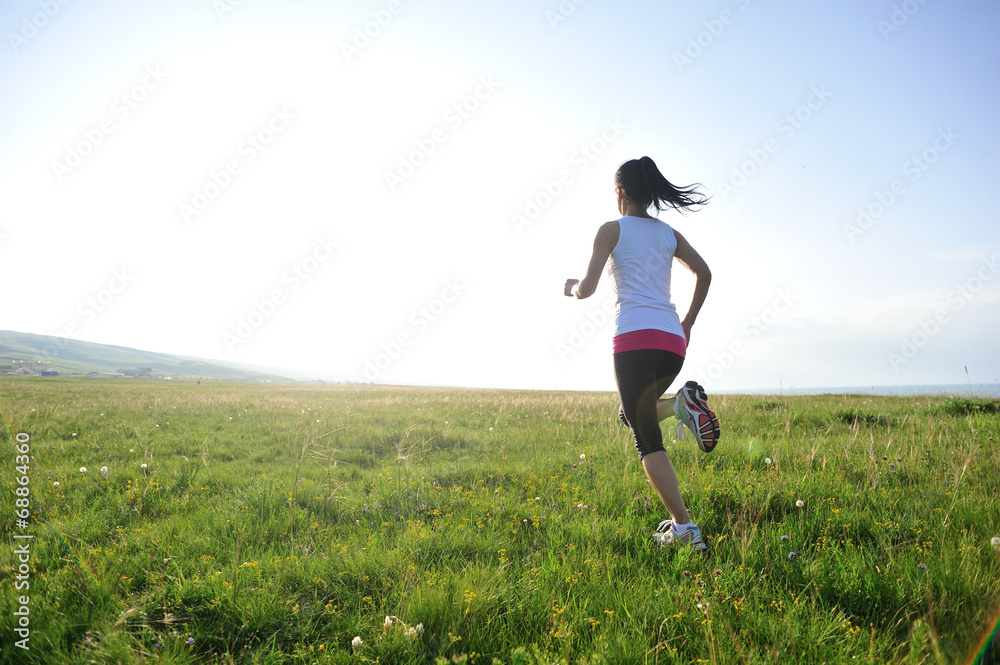 Runner athlete legs running on grass seaside Runner athlete legs running on grass seaside