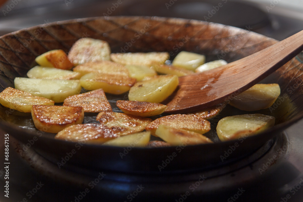 Bratkartoffeln in Eisenpfanne mit Pfannenwender – Stock-Foto | Adobe Stock