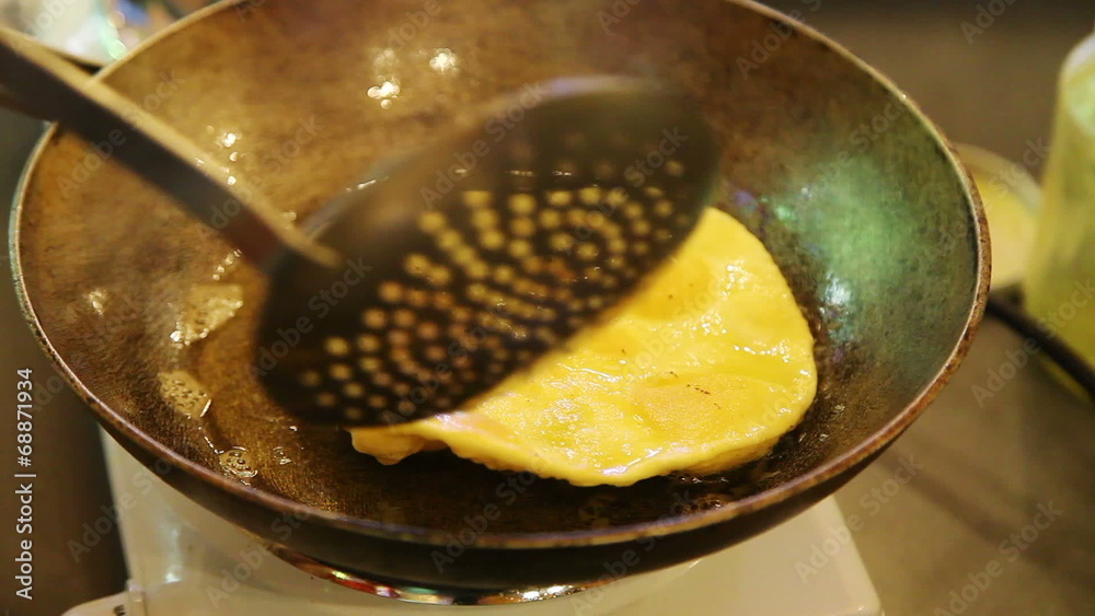 Closeup of turning chapati on frying pan