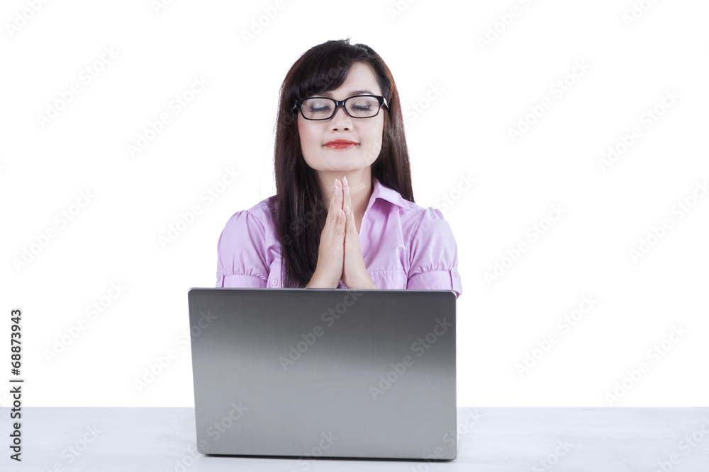 Businesswoman praying while working isolated Businesswoman praying while working isolated