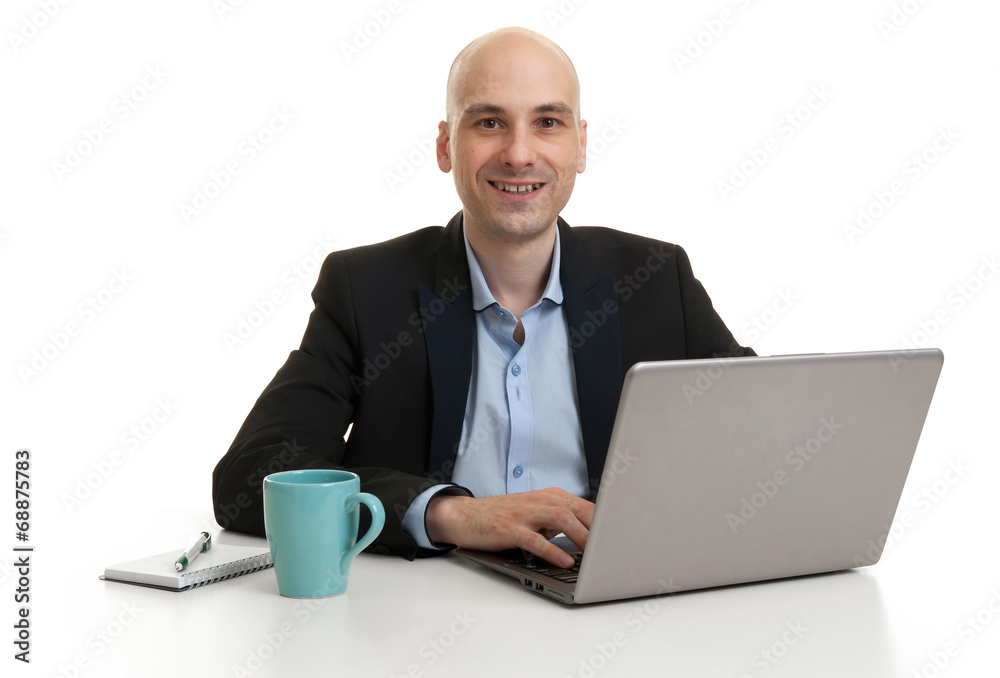 businessman sitting at desk, working on laptop computer businessman sitting at desk, working on laptop computer