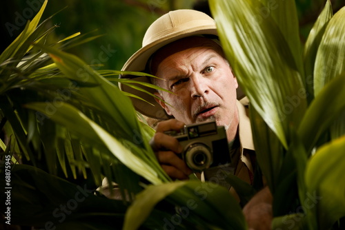 Explorer photographer hiding in vegetation photo