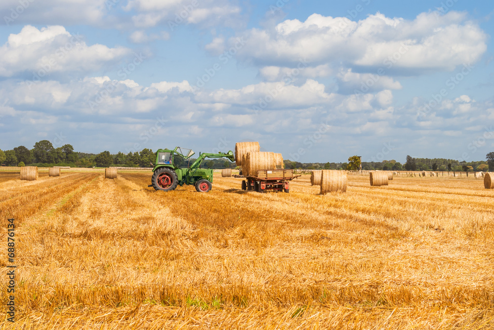 Obraz premium Tractor Hauling Hay Bales on Trailer