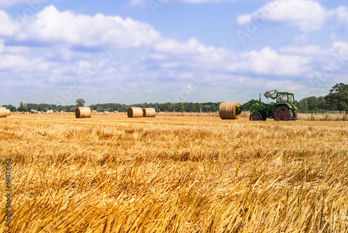 Fotografi Tractor hauling bale of hay
